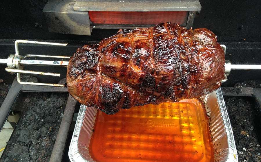 Roast turning on a rotisserie spit under a glowing infrared rear burner (representative photo)