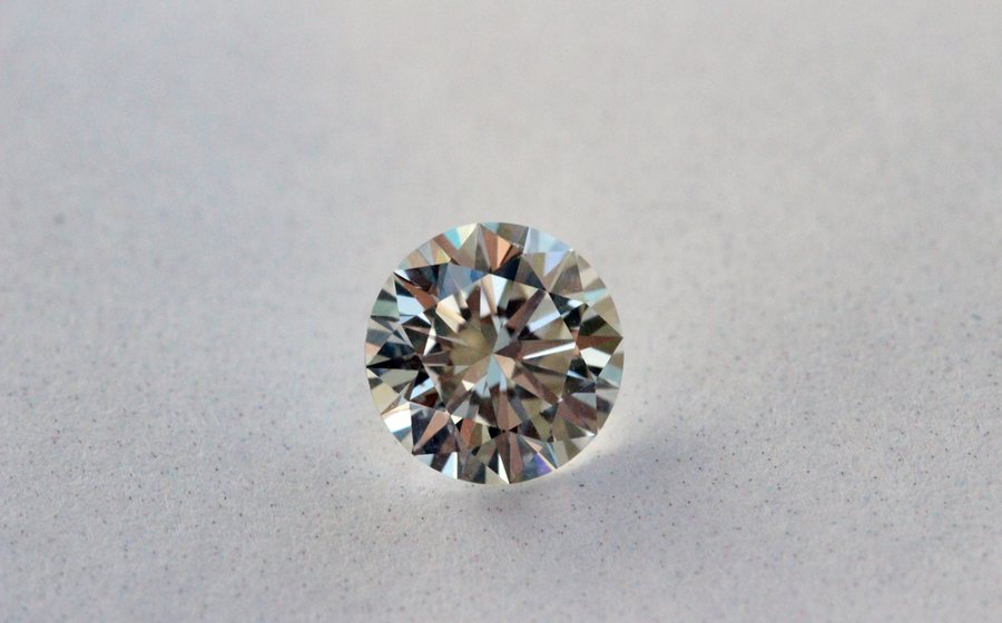 Brilliant-cut diamond on a soft grey background