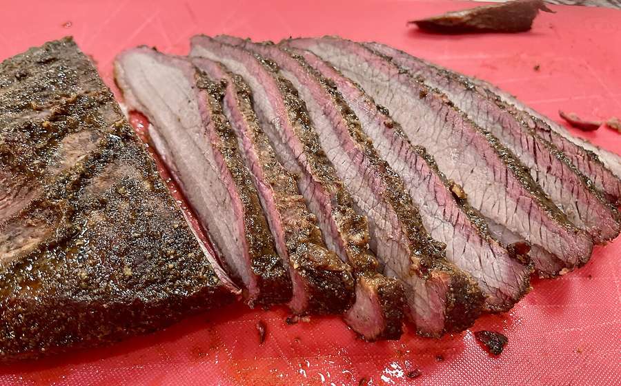Sliced smoked brisket with a dark bark on butcher paper